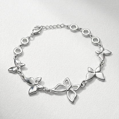 Damenarmband mit mehreren glatten Metallreihen und polierten Kugelenden, in silberner Optik am Handgelenk und als Detailansicht dargestellt