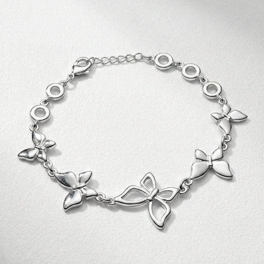 Damenarmband mit mehreren glatten Metallreihen und polierten Kugelenden, in silberner Optik am Handgelenk und als Detailansicht dargestellt