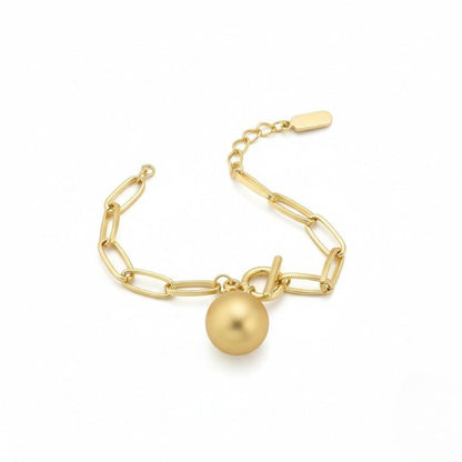 Goldfarbenes Damen-Gliederarmband mit Kugelanhänger, getragen am Handgelenk und in Nahaufnahme dargestellt