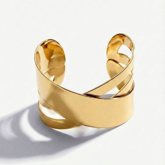 Goldfarbenes Damen-Armreif-Armband mit breitem Überkreuz-Design, getragen am Handgelenk und in Detailansicht dargestellt