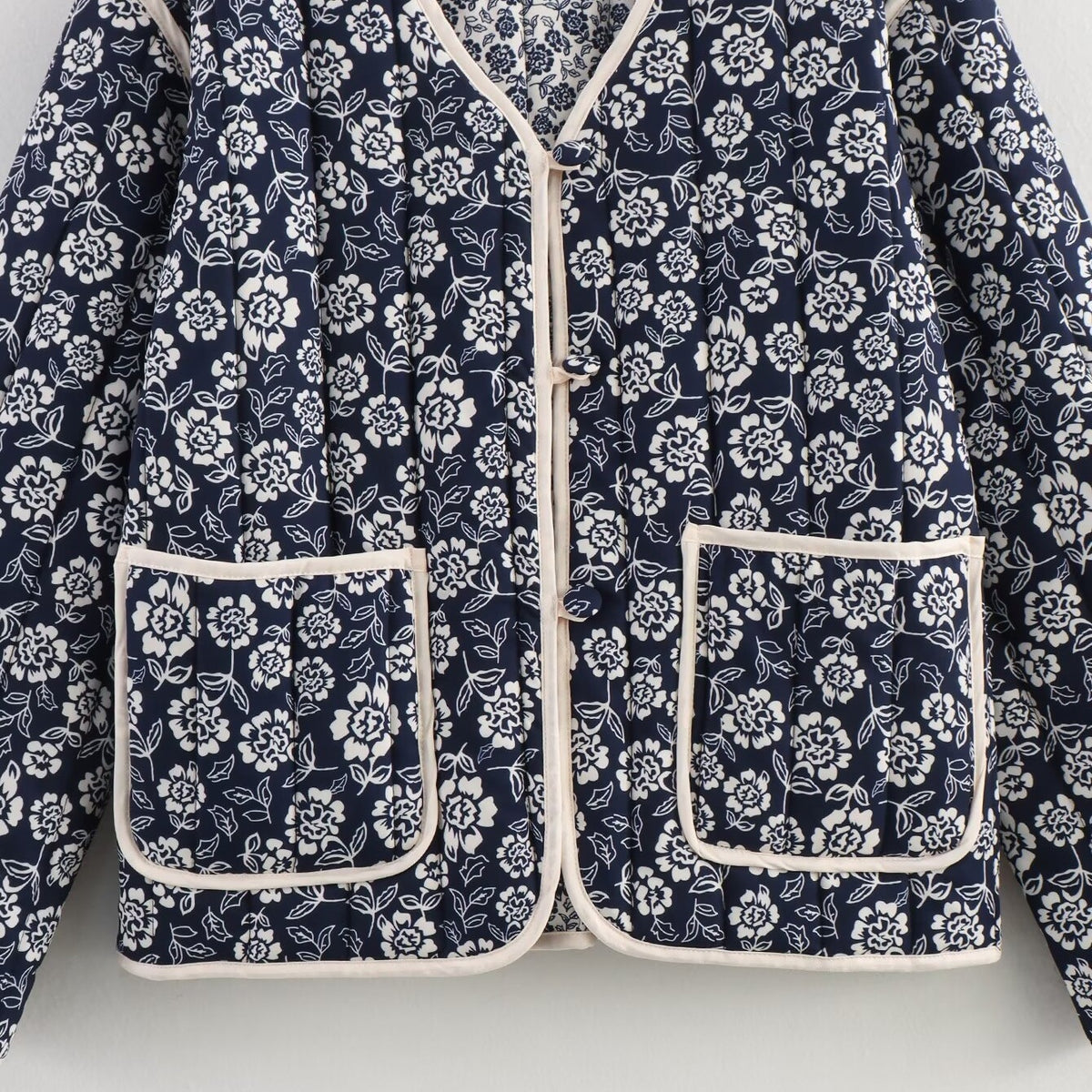 Ladies quilted jacket with floral allover, V-neck, contrast piping and patch pockets Shop Velvia